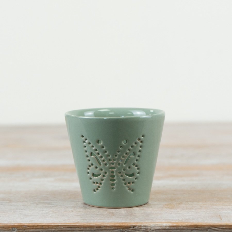 Delicate sage green candle holder featuring an intricate butterfly cut-out design.