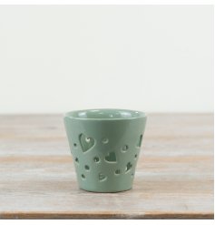 This delicate candle holder showcases a smooth glaze and charming mini heart cutouts.