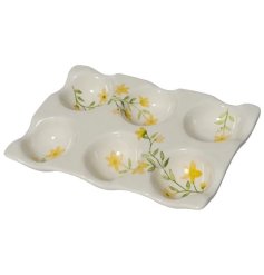 A charming stoneware egg holder with a pretty yellow floral design. 