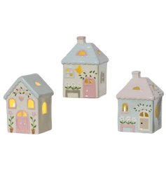 A mix of 3 charming cottage style porcelain houses, each with warm glow LED lights. 