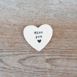A dainty heart token made from porcelain with a meaningful quote embossed alongside a tiny heart motif