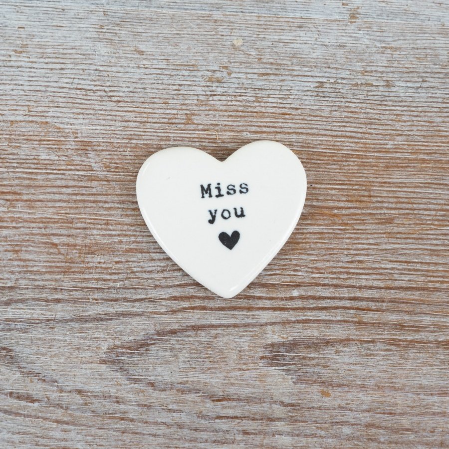Porcelain heart token with a delicate embossed quote and a small heart detail.