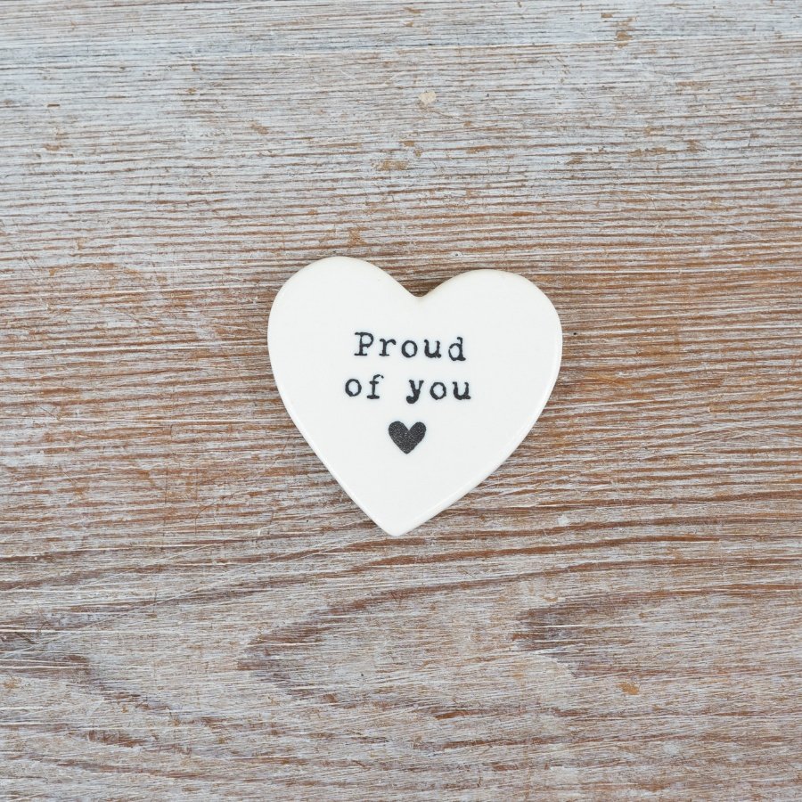 A heartfelt token embossed with proud of you in black and a delicate heart below—simple and meaningful.