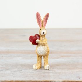 Adorable bunny clutching a beautiful red heart.