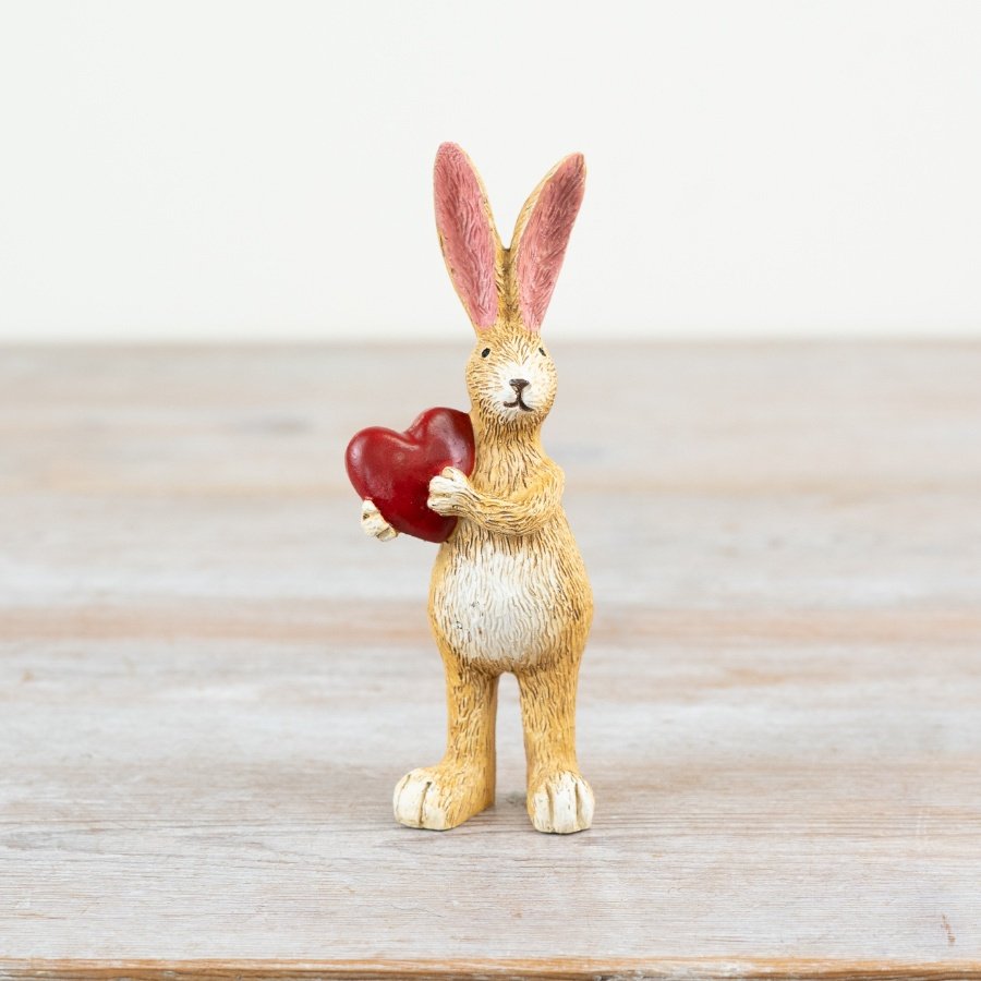 Adorable bunny clutching a beautiful red heart.