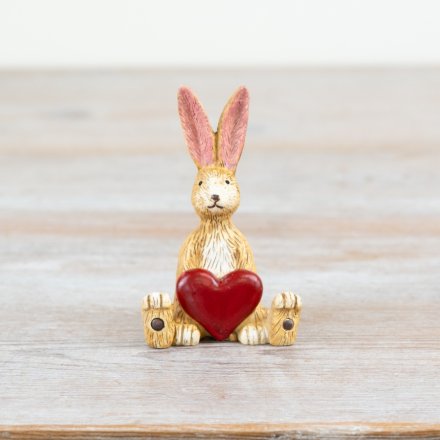 A charming Jasper Rabbit sitting with a ruby red heart.