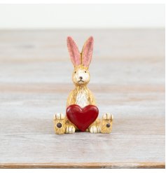 A charming Jasper Rabbit sitting with a ruby red heart.