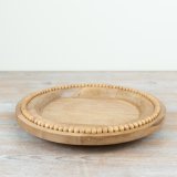 A chic wooden round plate with beading around the rim.