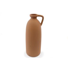   a stylish tall terracotta coloured vase 