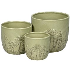 Add a touch of nature to your home with this set of three embossed green stoneware planters,