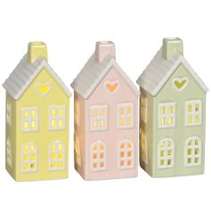 Delight in the warm glow of this charming porcelain LED house ornament