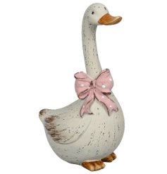 A delightful duck stood proudly whilst wearing a pink and white polkadot bow.