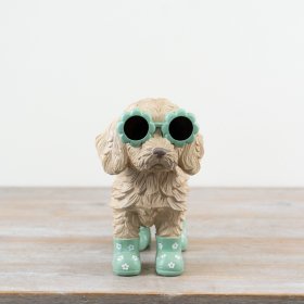 Adorable Cockapoo statue wearing playful flower-shaped glasses.