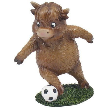 a fun cow figurine playing football
