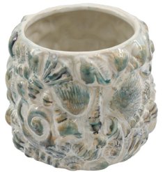 Bring coastal vibes to your space with this charming shell-inspired plant pot.