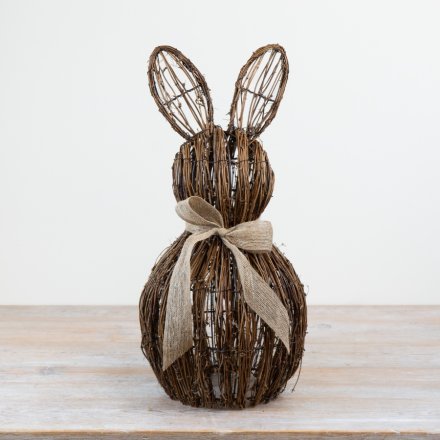 Adorable rattan bunny figurine seated with a charming bow accessory.