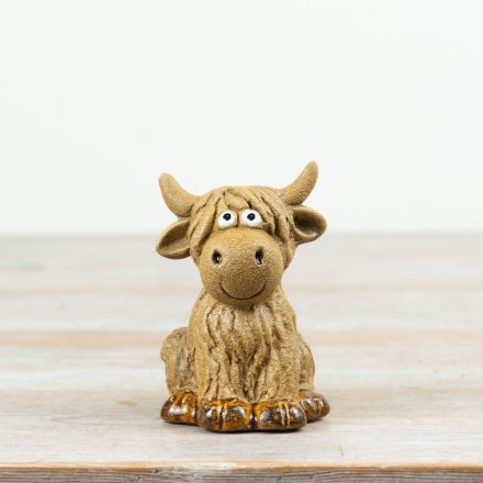 Adorable sitting highland cow ornament with googly eyes, perfect for adding charm to any space.