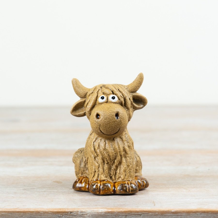 Adorable highland cow ornament with googly eyes, perfect for sitting display.