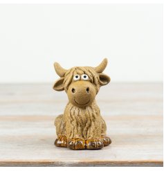 Adorable sitting highland cow ornament with googly eyes, perfect for adding charm to any space.