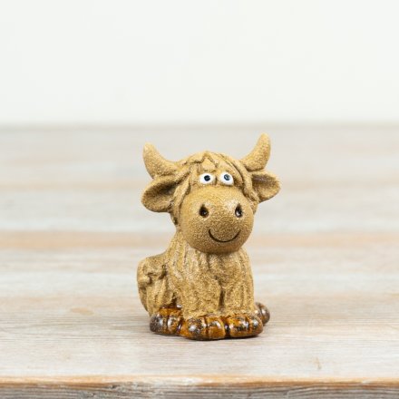 Adorable decorative sitting cow figurine to brighten any space.