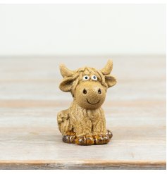 Adorable decorative sitting cow figurine to brighten any space.