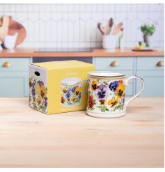 Delightful candle featuring a pansy motif, beautifully housed in a cozy mug.