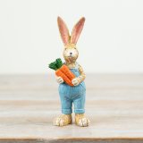 a charming rabbit figurine holding a bunch of carrots 