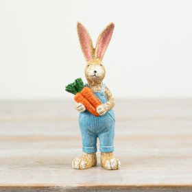 Adorable rabbit statue clutching a vibrant bunch of carrots.