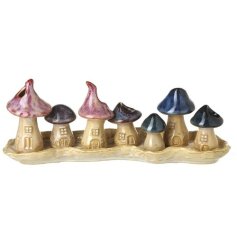 A delightful set of glazed toadstools showcased on a coordinating base.