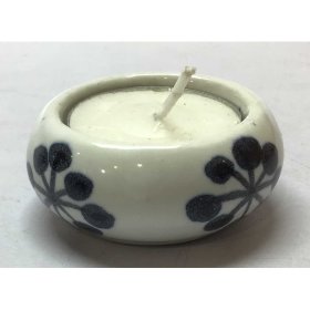 Delicate ceramic tea light holder adorned with a floral motif and a subtle clear glaze