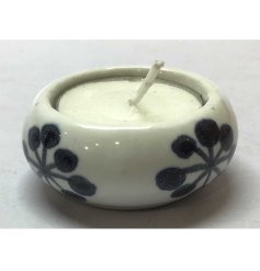 A dainty tea light holder finished with a floral pattern and a simple clear glaze.