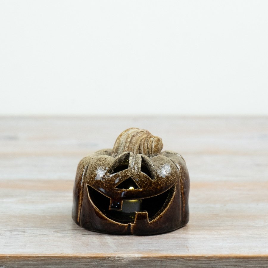 10cm ceramic jack o’lantern with rich brown glaze and traditional carved pumpkin face design.