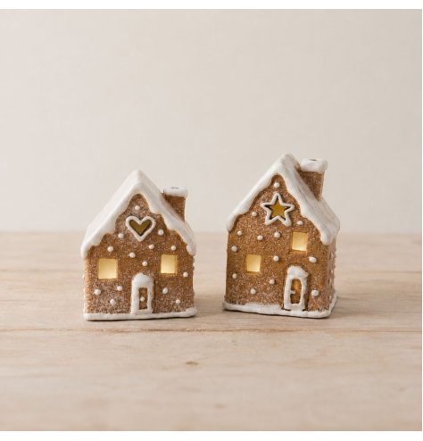 A festive gingerbread house tealight holder with icing-style detailing and cut-out windows that create a warm glow when 