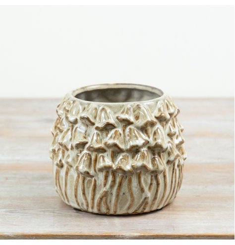 A rustic stoneware planter decorated with raised mushroom detailing and finished in warm neutral glaze tones. 