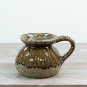 A characterful ceramic jug featuring a rich, reactive glaze in earthy brown and stone tones