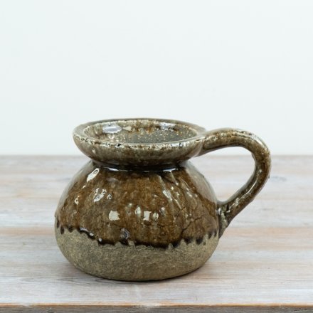 A decorative stoneware jug finished in a warm brown reactive glaze with natural stone detailing. I