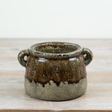 A characterful ceramic planter finished in a layered reactive glaze of warm browns and natural stone tones.