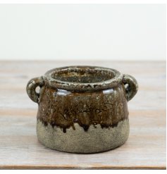 A distinctive ceramic planter featuring a layered reactive glaze in rich earthy browns blended with natural stone hues.
