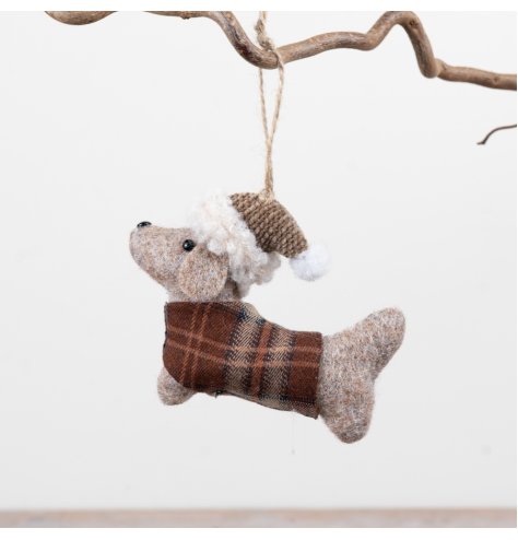A charming felt dog ornament dressed in a plaid coat and winter hat, complete with hanging string for easy display.
