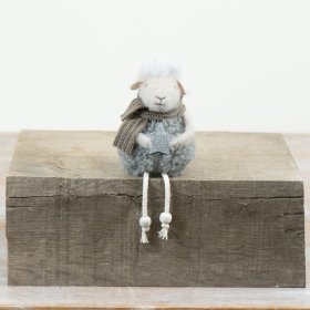 This 13cm sitting sheep ornament brings soft texture and gentle character to seasonal styling. 