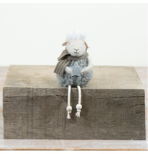 Soft fabric sheep ornament with seasonal details and charming dangling legs.