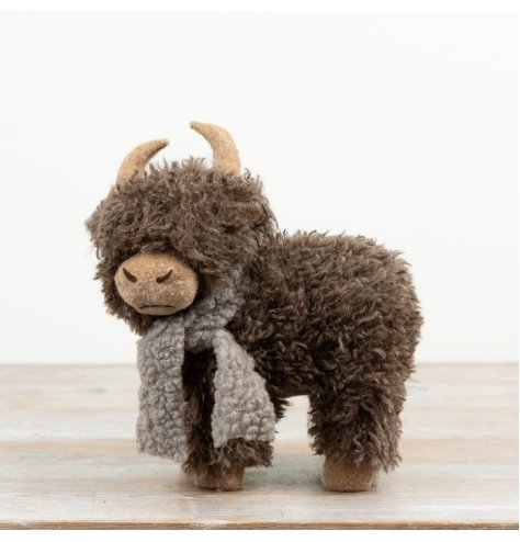 A charming freestanding Highland cow complete with textured fur and soft scarf detail. 