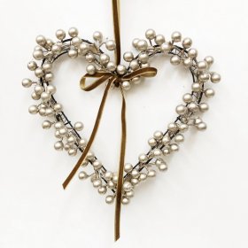 A decorative heart-shaped wreath crafted from metallic berry clusters set on a slim wire frame