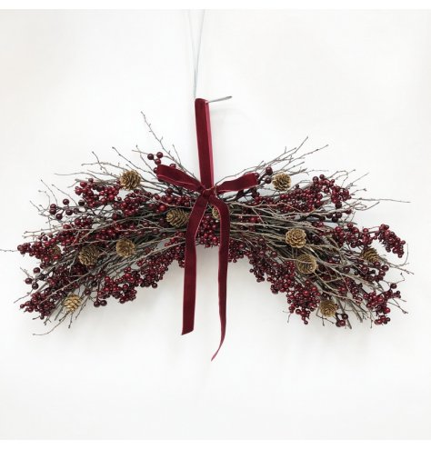 A festive hanging decoration featuring deep red berries.