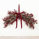 A festive hanging decoration featuring deep red berries.