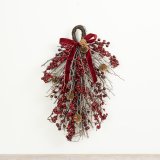 A traditional festive door hanging featuring red berries, twigs and pinecones