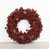 Traditional Christmas wreath adorned with lush, vibrant red berries for a festive touch.