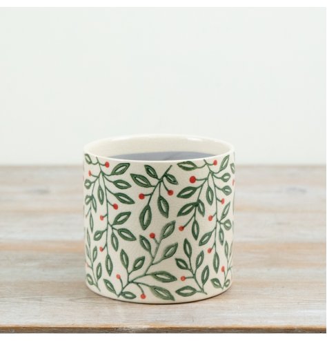 A decorative ceramic planter featuring a delicate all-over foliage design with green leaves and red berry accents.