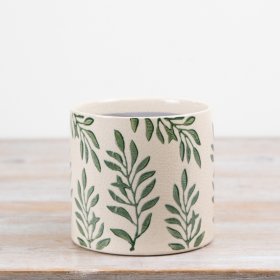 Ceramic planter features a repeating foliage motif in soft green tones set against a warm neutral background. 
