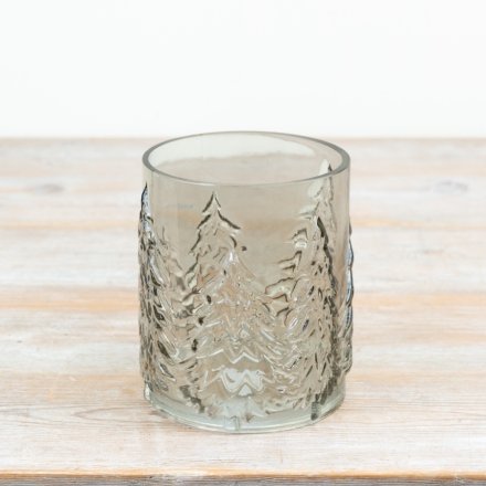 Smokey glass candle holder features embossed Christmas tree detailing that wraps around the glass